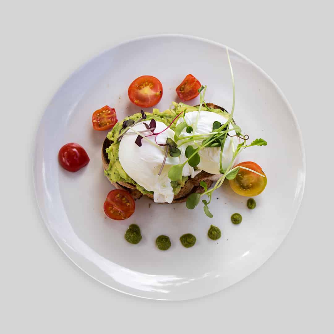 Poached Enriched eggs with smashed avocado on sourdough toast.