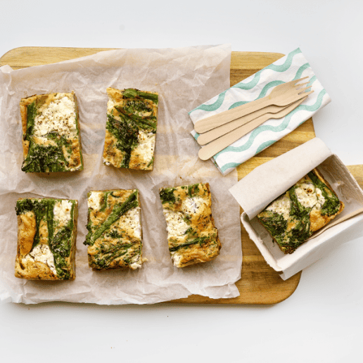 Six slices of Enriched eggs picnic frittata on a wooden chopping board.